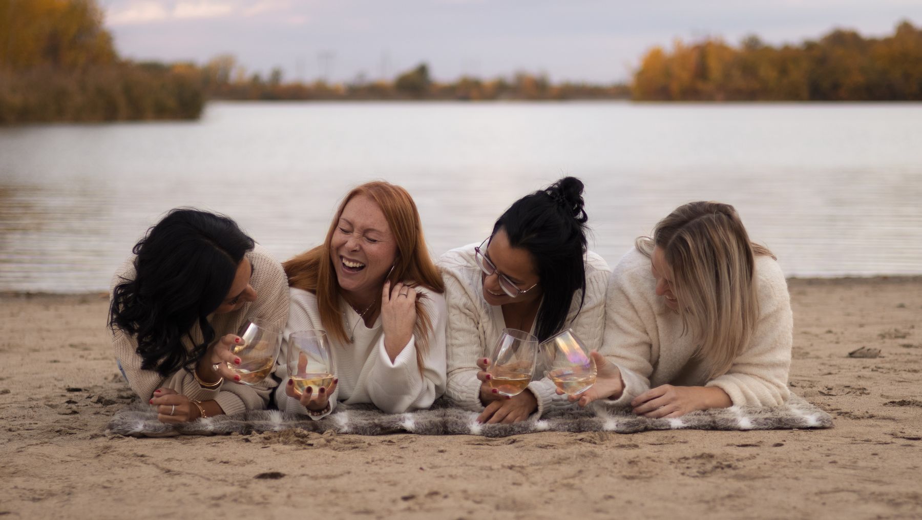 Amies allongées en cercle sur la plage, tête contre tête