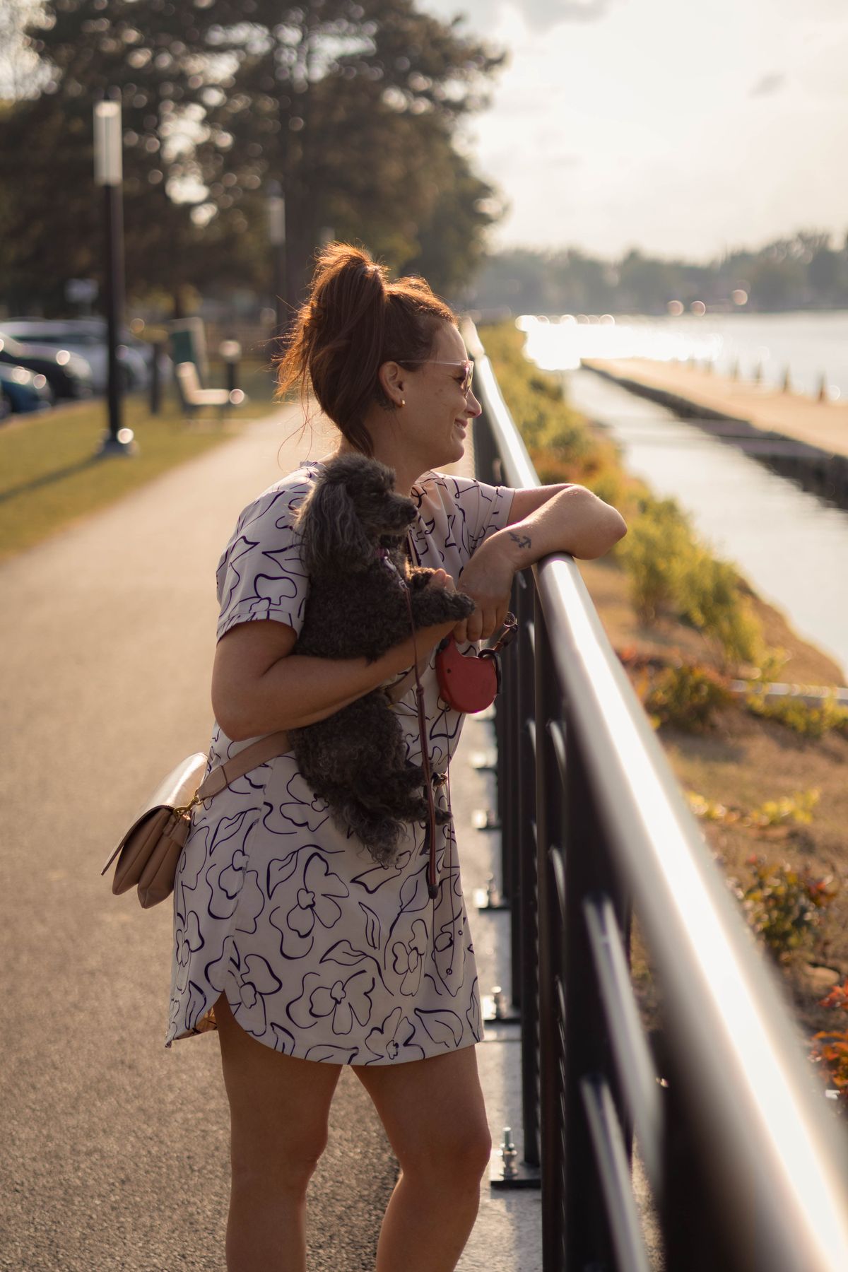 Personne câlinant son petit chien sur une passerelle au bord du canal